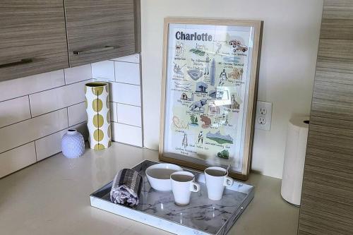 a kitchen counter with three cups and a refrigerator at League Flats Uptown at West Trade Street in Charlotte