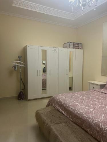 1 dormitorio con 1 cama y algunos armarios blancos en One bedroom apartment in Jimi, en Al Ain
