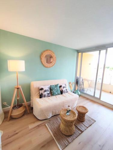 - un salon avec un canapé blanc et une fenêtre dans l'établissement L'Escapade : Charmant T2 -Parking gratuit, piscine, wifi, clim, à Gruissan