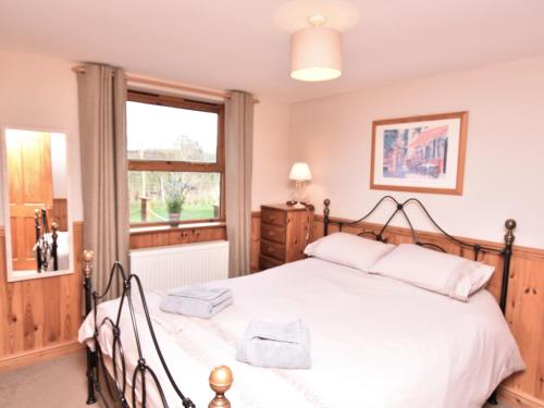 um quarto com uma grande cama branca e uma janela em 2 Bed in Ledbury 77377 