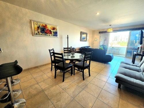 a living room with a table and chairs and a couch at Bahia del tezal 202b: 2BR/2BT Condo, Big pool, 5 minutes walk to Beach! in Cabo San Lucas
