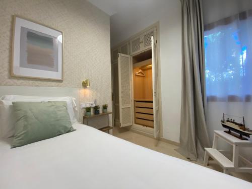 a bedroom with a white bed and a large window at Don Carlos Marbella Beach in Marbella