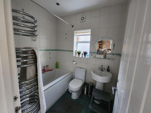 e bagno con servizi igienici, vasca e lavandino. di Countryside Home in London a Shirley