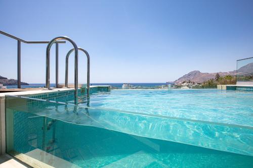 a large swimming pool with blue water at Aléa Villa Plakias in Plakias
