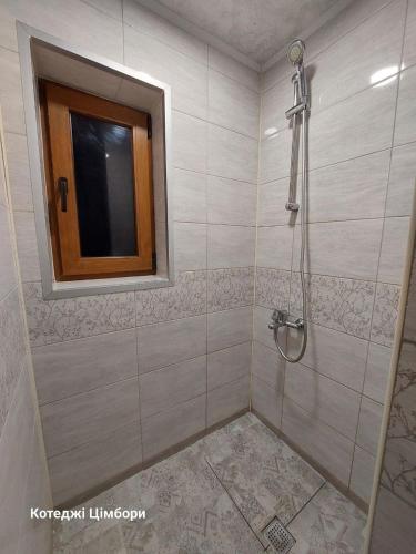 a bathroom with a shower with a window at Котеджі Цімбори in Yablunytsya