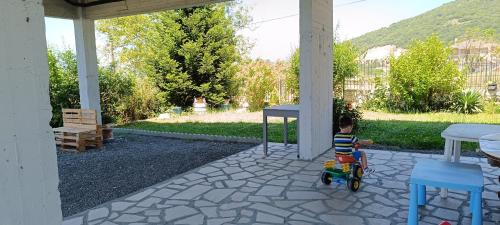 a little boy riding a toy bike on a patio at Pavlos House in Asfáka