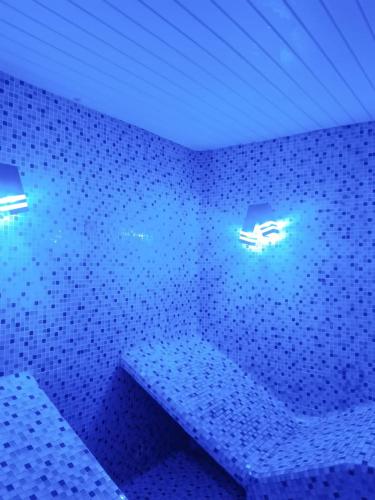 a bathroom with blue lights on a tiled wall at Cia’s Seaside Serenity @ Oceanic Unit 36 in Durban