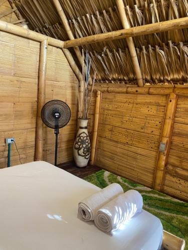 a room with a bed with towels and a fan at Guajira Beach in Ríohacha