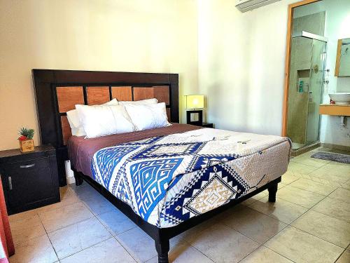a bedroom with a bed with a blue and white blanket at Bahia del tezal 202b: 2BR/2BT Condo, Big pool, 5 minutes walk to Beach! in Cabo San Lucas