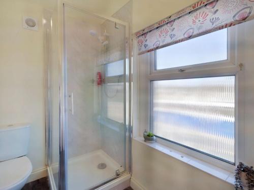 baño con ducha y aseo y ventana en 5 Bed in Morecambe 87639, en Heysham