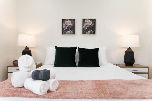 - une chambre avec un lit blanc et des serviettes dans l'établissement Be A Nomad Apartments Blocks to the Beach, à Jacksonville Beach