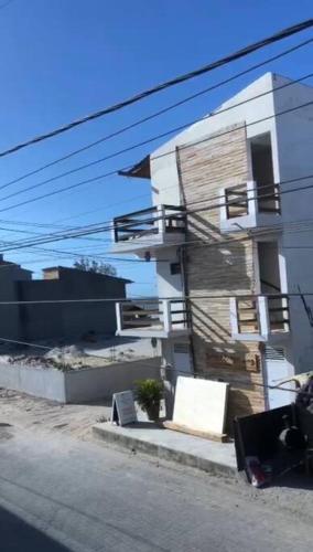 um edifício branco com escadas ao lado em Casa - 70 metros da praia em Cruz