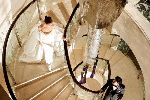 a bride and groom walking down a spiral staircase at The St. Regis Bangkok in Bangkok