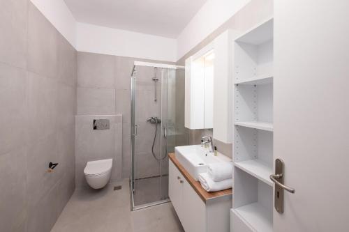 y baño con ducha, aseo y lavamanos. en Semi Basement Apartment by Sunshine Place World en Kalo Livadi