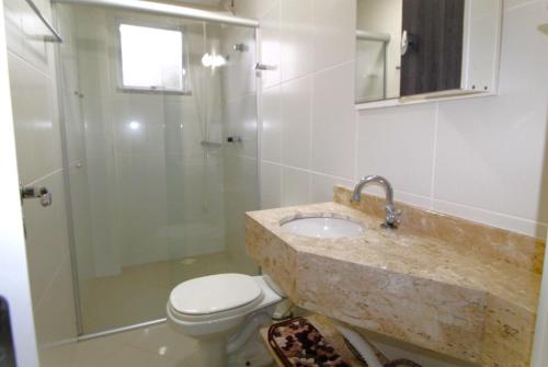 y baño con lavabo, ducha y aseo. en 1020 - Apto 03 dormitórios para locação em Bombinhas - Residencial Alameda Verde Apto 201, en Bombinhas