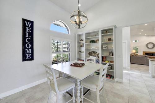 a white dining room with a white table and chairs at Direct boating access waterfront home with pool/spa in Marco Island