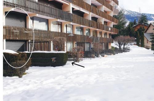 une cour couverte de neige devant un bâtiment dans l'établissement L’ALPIN AU PIED DES PISTES ET COMMERCES, à Saint-Chaffrey