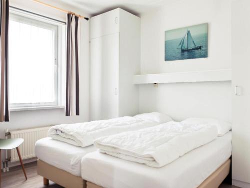 biała sypialnia z 2 łóżkami i oknem w obiekcie Amazing holiday home in Friesland with Sauna and outdoor Spa w mieście Earnewâld