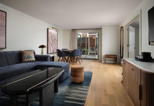 a living room with a blue couch and a table at The Union Station Nashville Yards, Autograph Collection in Nashville