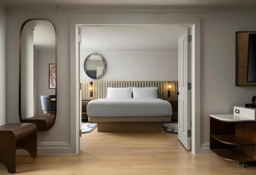 a bedroom with a white bed and a mirror at The Union Station Nashville Yards, Autograph Collection in Nashville