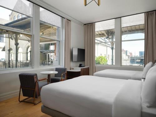 a hotel room with two beds and a tv at The Union Station Nashville Yards, Autograph Collection in Nashville