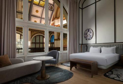 a hotel room with a bed and a couch at The Union Station Nashville Yards, Autograph Collection in Nashville