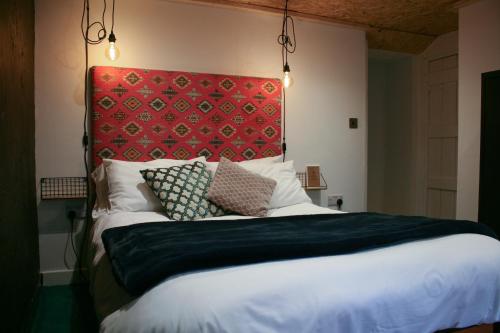 a bedroom with a large bed with a red headboard at Fern Studio 1 Bedroom Apartment in Llangollen