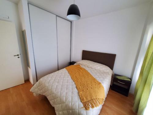 Un dormitorio con una cama con una manta. en Moderno y luminoso departamento en Villa Urquiza en Buenos Aires