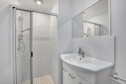 ein weißes Bad mit einem Waschbecken und einer Dusche in der Unterkunft Lazy Days in Point Lookout
