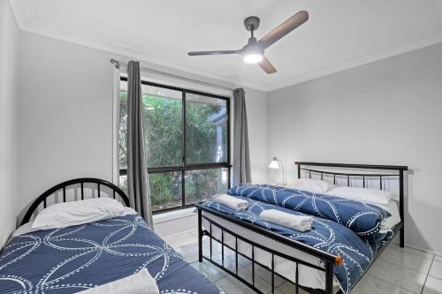 a bedroom with two beds and a window at Lazy Days in Point Lookout