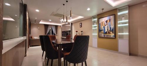 Goldcrest Luxury Apartments في لاهور: مطبخ وغرفة طعام مع طاولة وكراسي