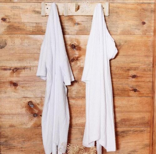 two white towels hanging on a wooden wall at Glamping Isaju , Santa Helena , Valle del Cauca in El Cerrito