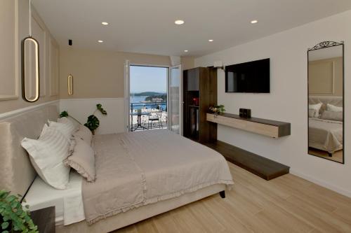 a bedroom with a large bed and a balcony at Villa Milton Luxe Rooms in Hvar
