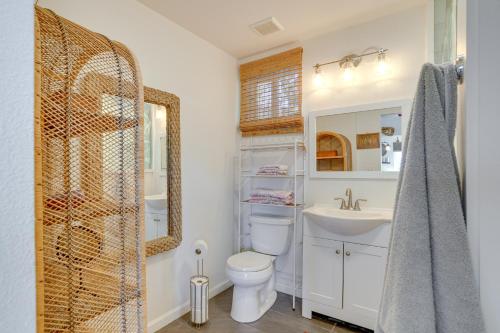 a bathroom with a toilet and a sink and a mirror at Inviting Aiea Bungalow with Balcony, Grill and Views! in Aiea