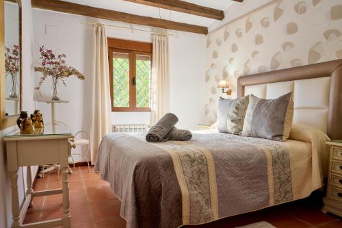1 dormitorio con cama, mesa y ventana en Casa Rural Vistaverde en Luque