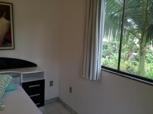a bedroom with a bed and a large window at Hotel Pousada Reimar in Balneário Camboriú