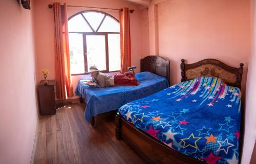 a bedroom with two beds and a dog laying on the bed at Ima Sumaj Hostel in Copacabana