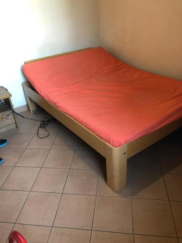 Una cama en una habitación con una sábana roja. en Ferme D’Herlaimont, en Chapelle-lez-Herlaimont