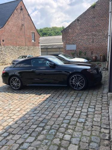 a black car parked on a brick driveway at Ferme D’Herlaimont in Chapelle-lez-Herlaimont