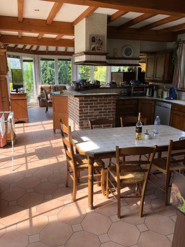 a kitchen with a table and chairs in a room at Ferme D’Herlaimont in Chapelle-lez-Herlaimont