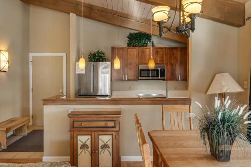 a kitchen with wooden cabinets and a table and a microwave at Woodbridge Condo by Snowmass Vacations in Snowmass Village