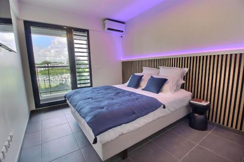 a bedroom with a large bed with a purple light at Appartement Sky Blue in Fort-de-France