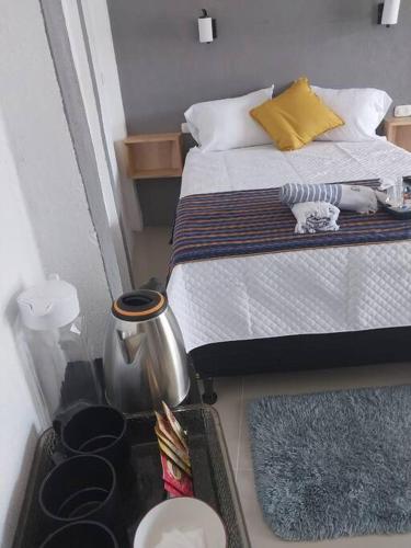 een kleine slaapkamer met een bed en een tafel met beddengoed bij Casa Beverly Xejuyu II in San Pedro La Laguna