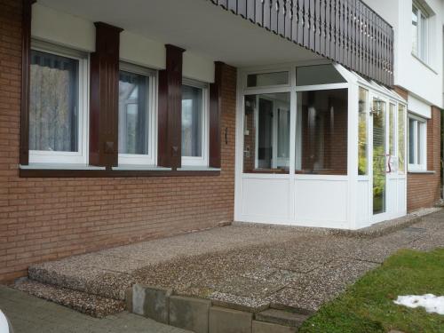 uma casa de tijolos com uma porta branca e janelas em FeWo Ruhe em Olsberg
