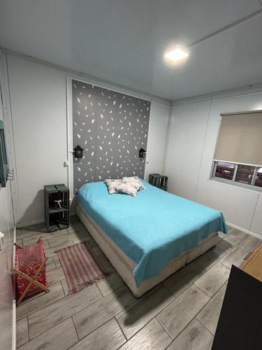 Schlafzimmer mit einem Bett mit blauer Decke in der Unterkunft Casas en Solis - Las Negritas in Balneario Solís