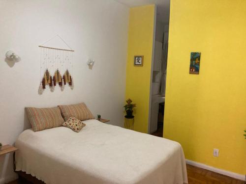 リオデジャネイロにあるQuarto privativo em apartamentoの黄色の壁のベッドルーム1室