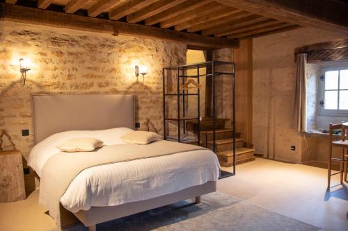 um quarto com uma cama num quarto com paredes de pedra em Châteauneuf Suites em Châteauneuf
