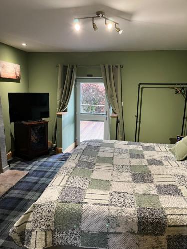 a bedroom with a bed and a television and a window at White Side Cottage in Haltwhistle
