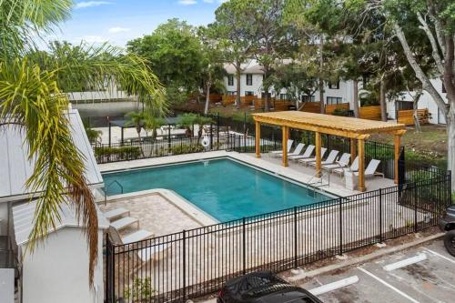 a swimming pool with a table and a fence at Cozy Townhouse - Gym Pool Golf Fast WiFi 2B2B in Tampa