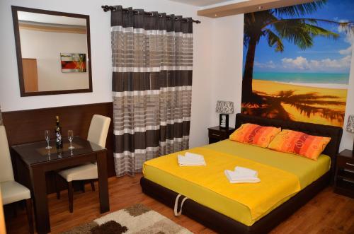 a bedroom with a bed and a table and a palm tree at Apartments Leo in Trebinje